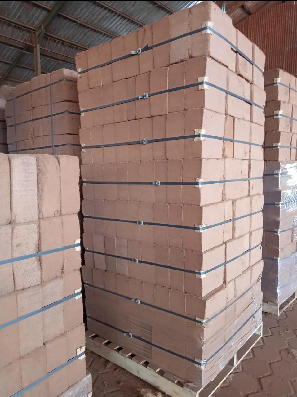 Stacked compressed cocopeat blocks strapped together in a warehouse